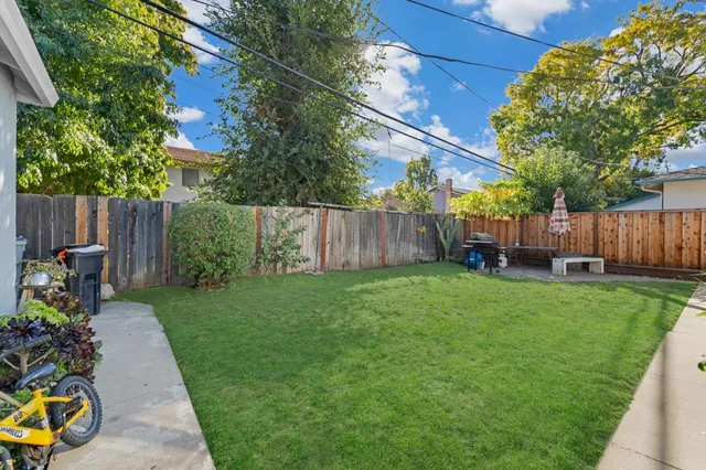 a backyard of a house with table and chairs
