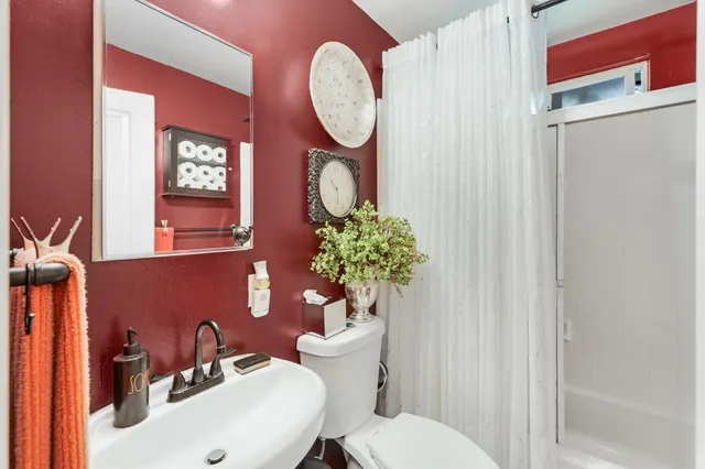 a bedroom with a bed table flowerpot and window