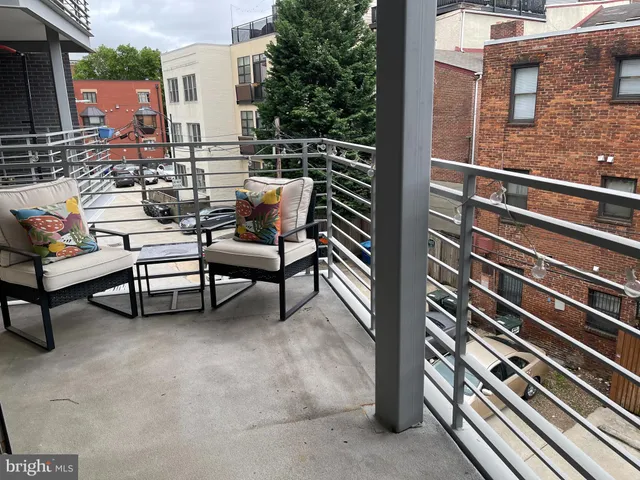 a couple of benches with some trees in front of it