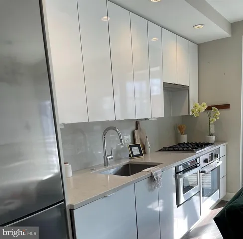 a kitchen with appliances a sink and cabinets