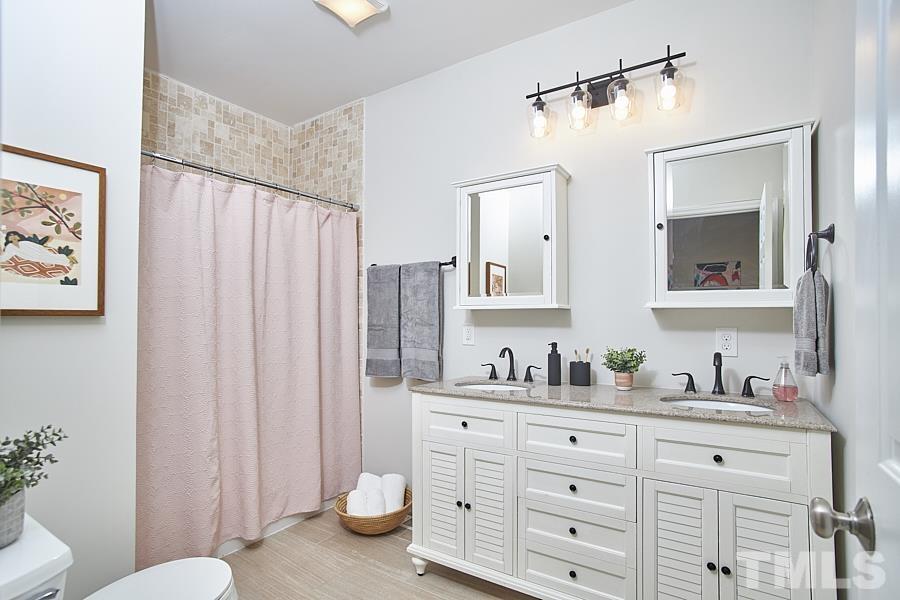 2203 Chapel Hill Road Durham, NC 27707 - Photo 25 of 37 a bathroom with a granite countertop sink toilet and shower
