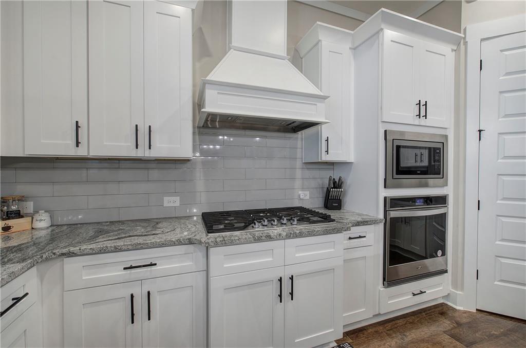 503 London Road Ball Ground, GA 30107 - Photo 13 of 55 a kitchen with granite countertop white cabinets and white appliances