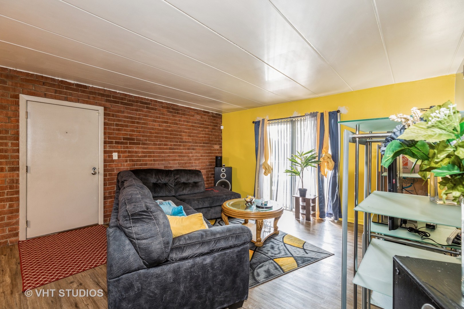 17001 Albany Avenue, Unit 101 Hazel Crest, IL 60429 - Photo 3 of 10 a living room with furniture a flat screen tv and floor to ceiling window