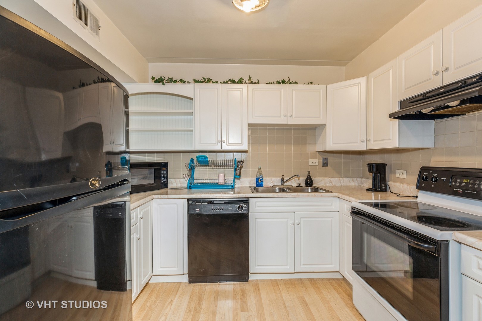 17001 Albany Avenue, Unit 101 Hazel Crest, IL 60429 - Photo 4 of 10 a kitchen with cabinets appliances and a wooden floor