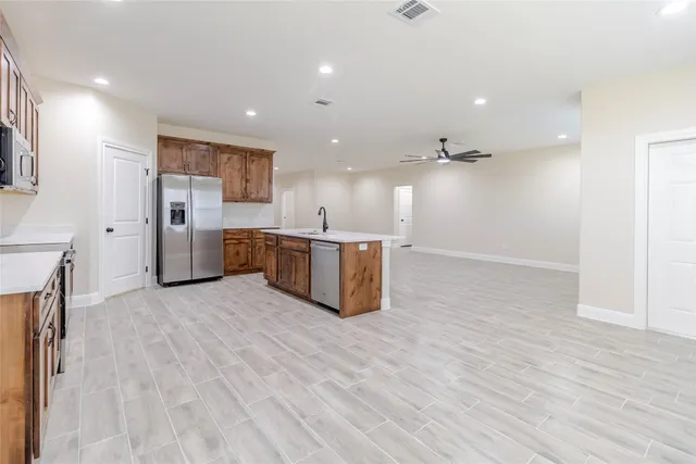 a kitchen with stainless steel appliances granite countertop a sink a refrigerator and cabinets