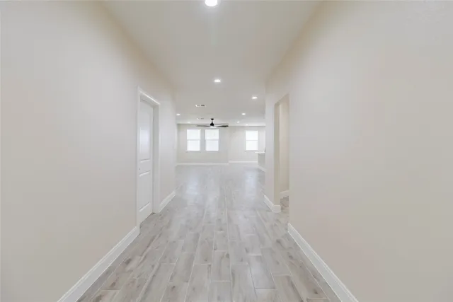 a view of a big room with wooden floor and windows