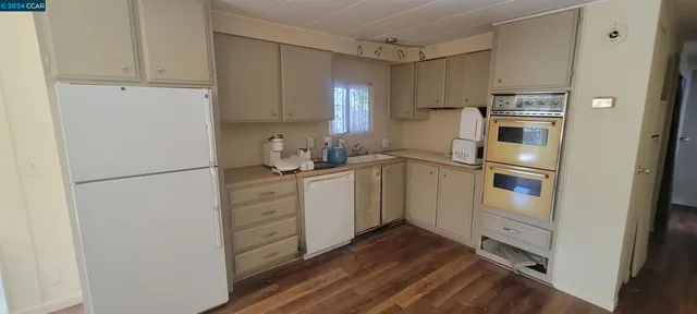 a kitchen with a refrigerator and white cabinets