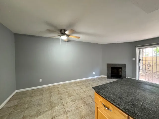 an empty room with windows and fireplace