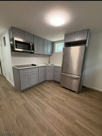 a kitchen with stainless steel appliances granite countertop a refrigerator a stove a sink and a microwave