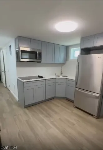 a kitchen with stainless steel appliances a refrigerator sink and microwave