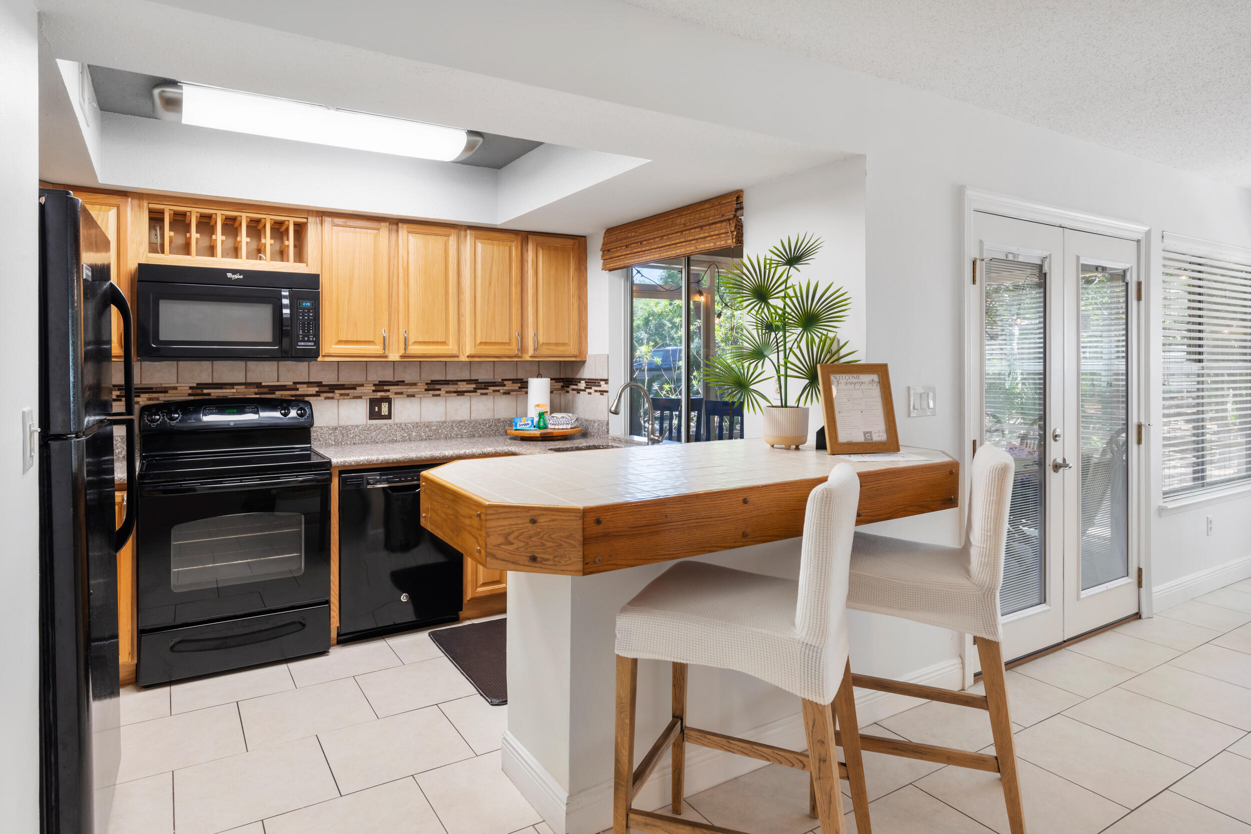 9815 Highway 98, Unit 144 Miramar Beach, FL 32550 - Photo 14 of 70 a kitchen with stainless steel appliances kitchen island granite countertop a table chairs and a refrigerator
