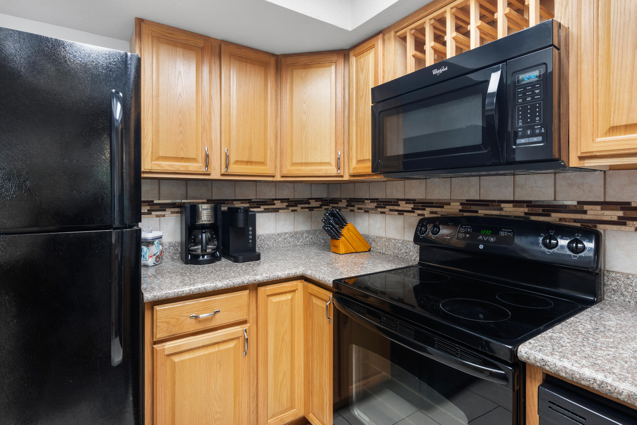 9815 Highway 98, Unit 144 Miramar Beach, FL 32550 - Photo 16 of 70 a kitchen with granite countertop a stove a sink and a microwave