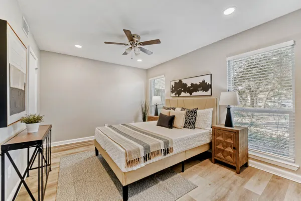 a bedroom with a bed table chair and a window