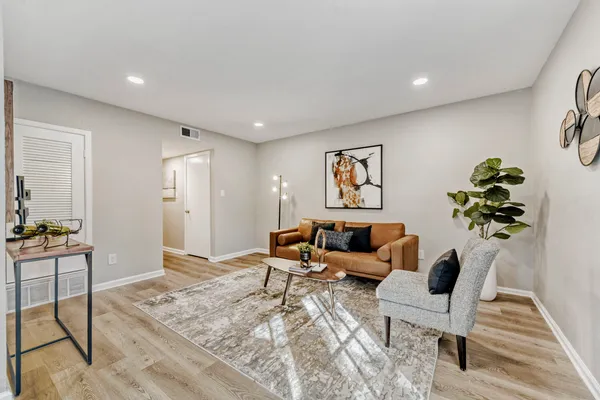 a living room with furniture and wooden floor