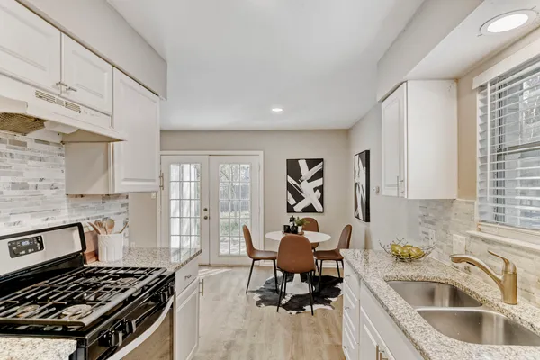 a kitchen with stainless steel appliances granite countertop a sink stove and cabinets
