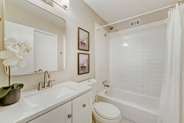 a bathroom with a granite countertop sink a toilet and shower
