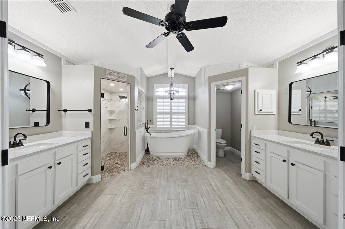 4032 Lonicera Loop St. Johns, FL 32259 - Photo 28 of 113 a bathroom with a double vanity sink a toilet a mirror and shower