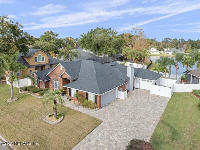 a view of a house with a yard and palm trees