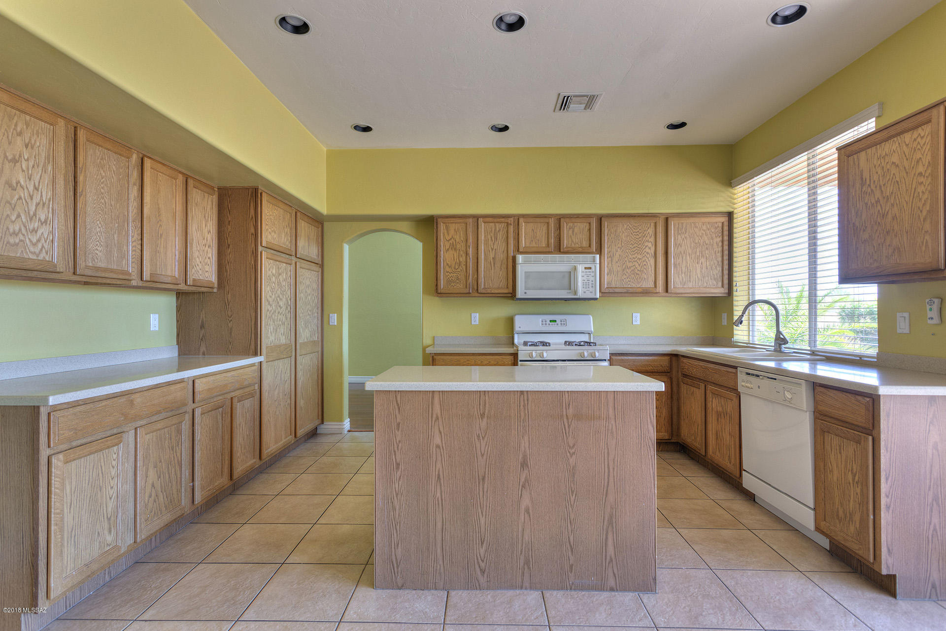 369 Via Capri Rio Rico, AZ 85648 - Photo 10 of 31 a kitchen with kitchen island granite countertop a stove top oven sink and cabinets