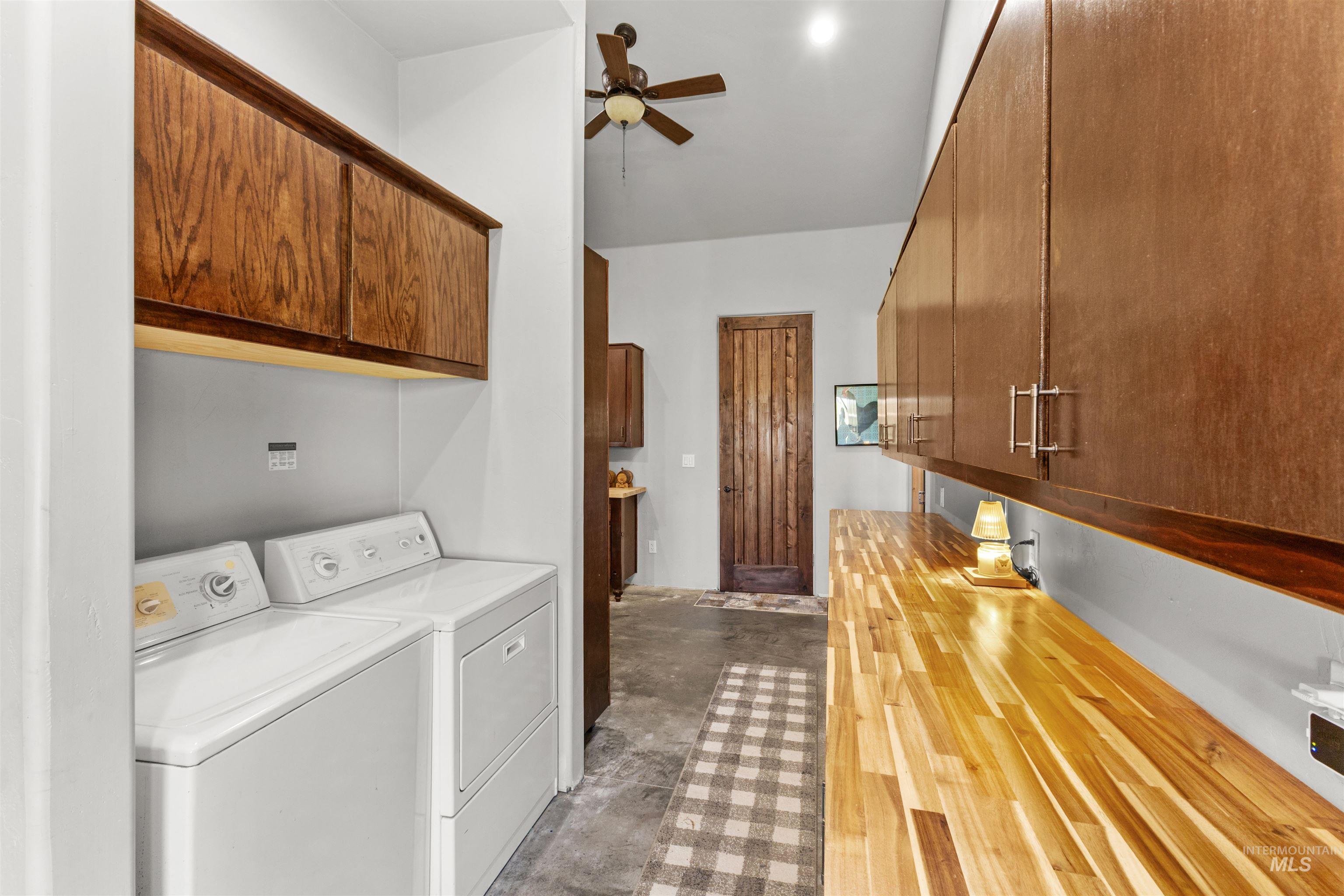 1030 Desert Glen Road Adrian, OR 97901 - Photo 38 of 47 Laundry area featuring extensive wood-finish cabinetry, a lengthy wood-finish countertop, and concrete-finish flooring