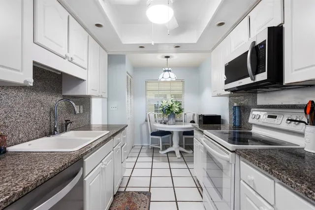a kitchen with stainless steel appliances granite countertop a refrigerator and a sink