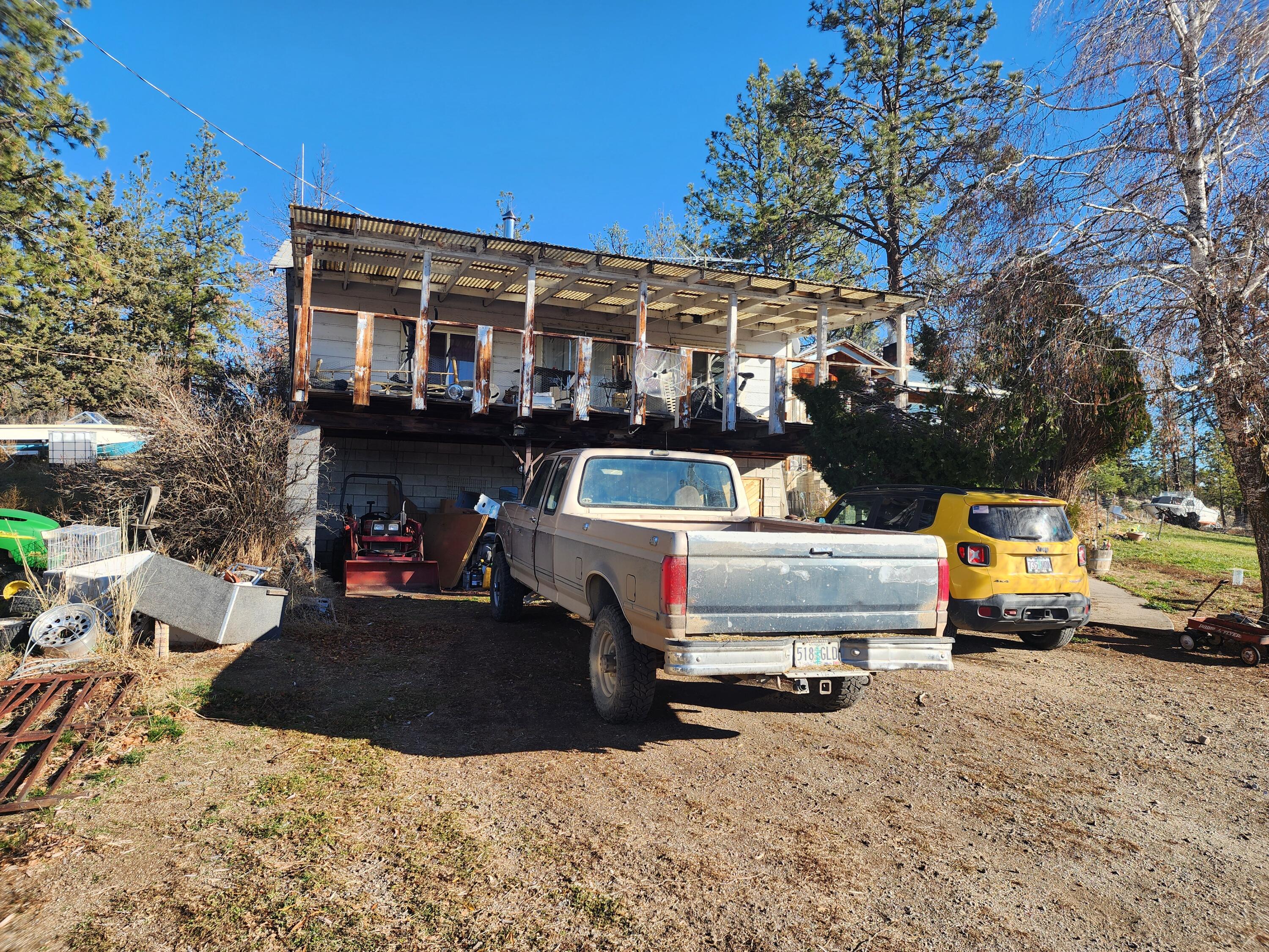 29151 Beatty Drive Beatty, OR 97621 - Photo 2 of 16 a view of a white house with a bed chairs and a fire pit