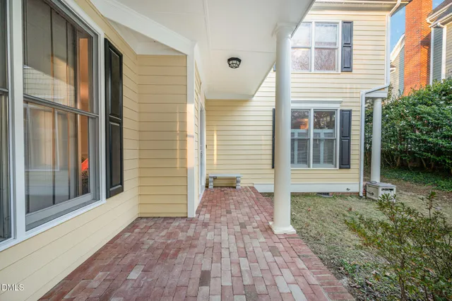 a view of a white house with large windows and a large tree