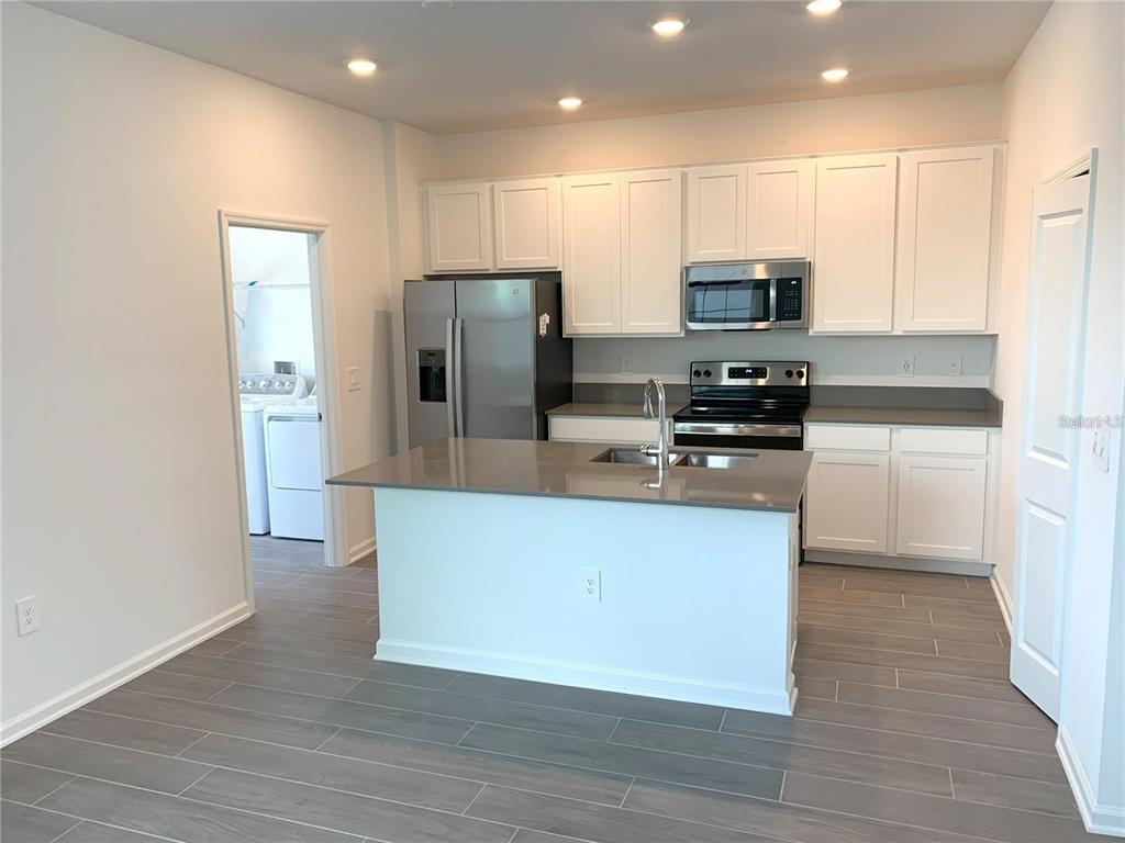 15609 Water Spring Boulevard Winter Garden, FL 34787 - Photo 12 of 36 a kitchen with stainless steel appliances a refrigerator and a stove top oven
