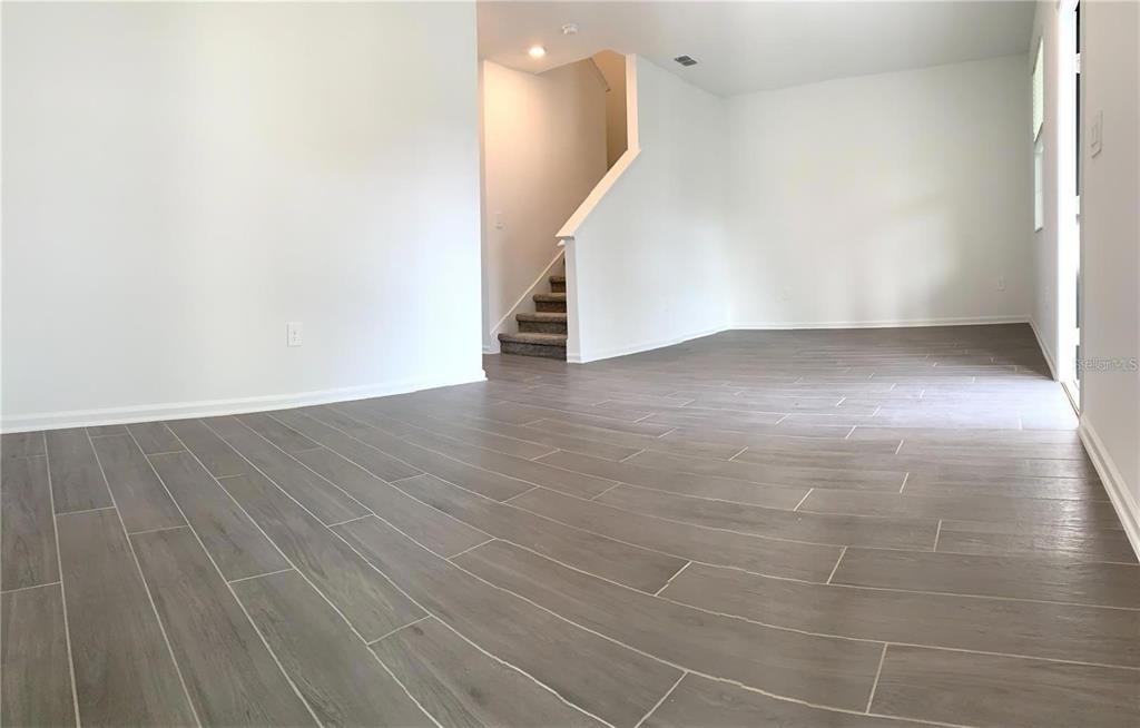15609 Water Spring Boulevard Winter Garden, FL 34787 - Photo 8 of 36 a view of a room with wooden floor and white walls