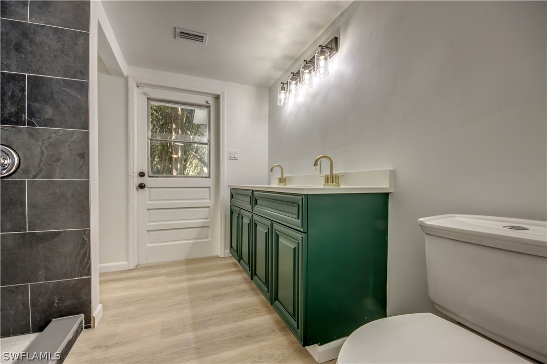 275 Trader Road Fort Denaud, FL 33935 - Photo 17 of 32 a bathroom with a sink a toilet a mirror and vanity