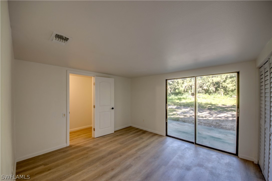 275 Trader Road Fort Denaud, FL 33935 - Photo 21 of 32 a view of an empty room with wooden floor and a window