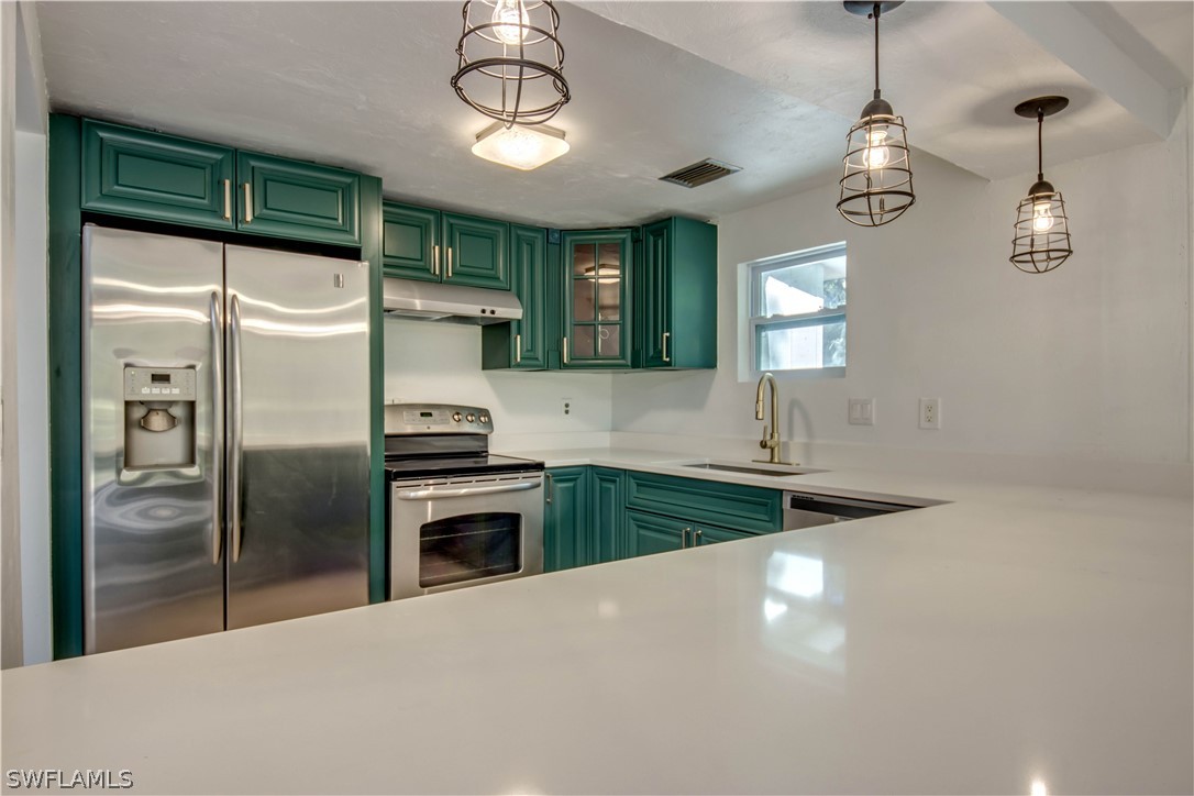 275 Trader Road Fort Denaud, FL 33935 - Photo 10 of 32 a kitchen with stainless steel appliances granite countertop a refrigerator a oven and a sink with large window