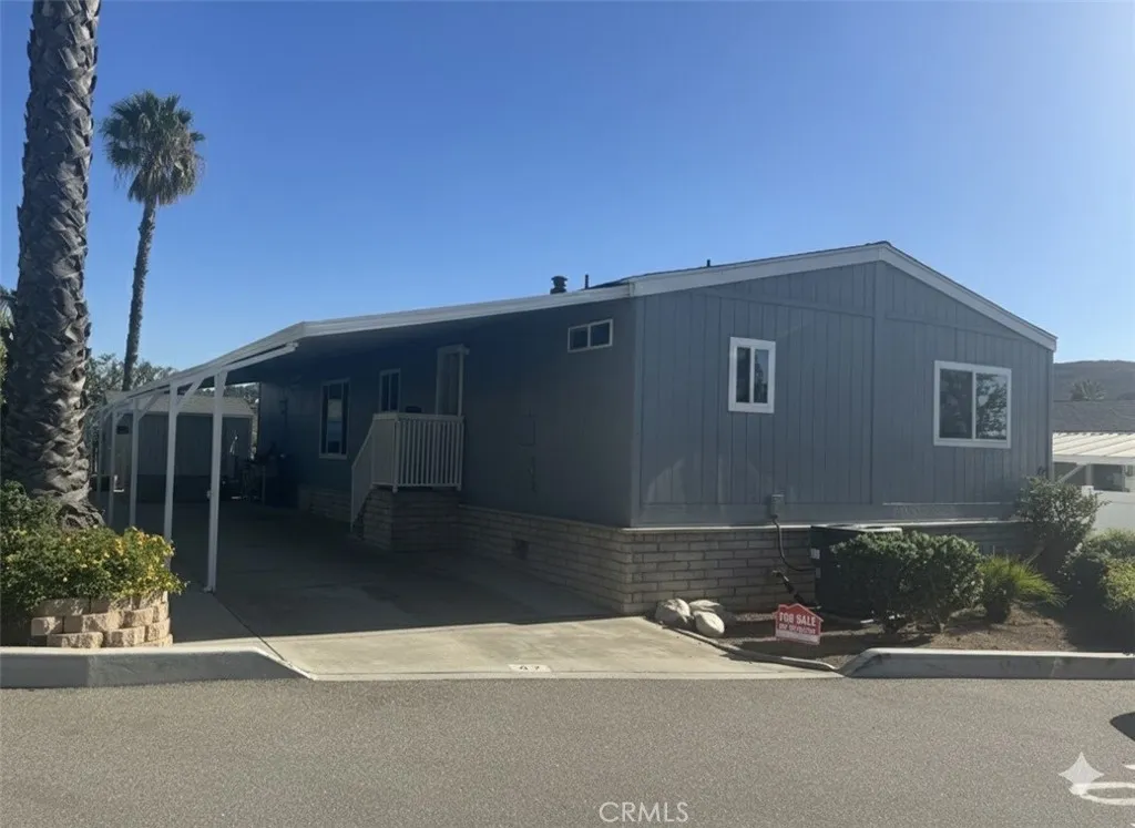 15181 Van Buren, Unit 47 Riverside, CA 92504 - Photo 3 of 20 a front view of a house with a yard and garage