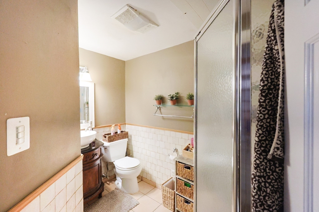 273 Tremont Street Fall River, MA 02720 - Photo 16 of 37 a bathroom with a sink a toilet a mirror and shower