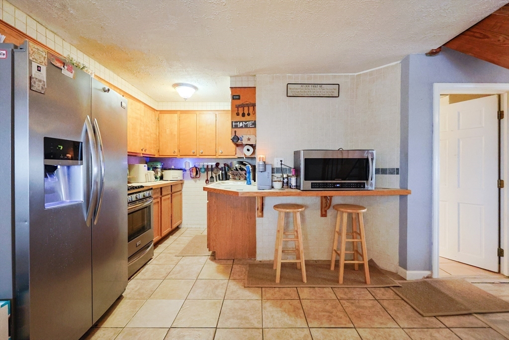 273 Tremont Street Fall River, MA 02720 - Photo 10 of 37 a kitchen with stainless steel appliances a refrigerator sink and microwave