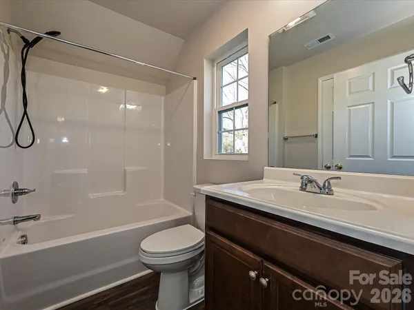 a bathroom with a granite countertop sink toilet a shower and a mirror
