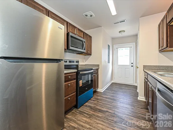 a kitchen with stainless steel appliances a refrigerator a stove top oven and cabinets
