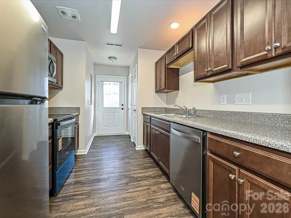 a kitchen with granite countertop stainless steel appliances and wooden cabinets