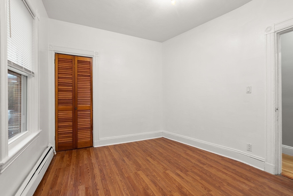 3 Spring Garden Street, Unit 1 Boston, MA 02125 - Photo 11 of 23 an empty room with wooden floor and windows