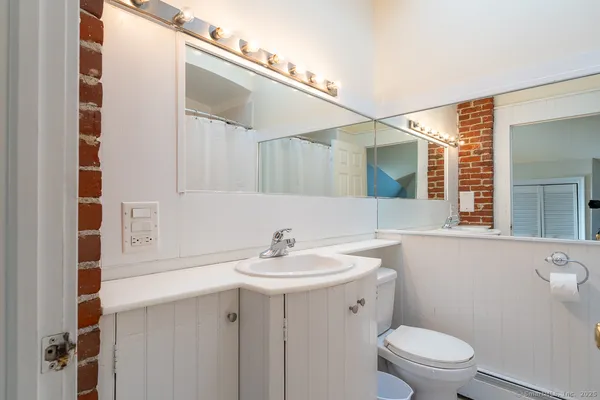 a bathroom with a sink a toilet and mirror