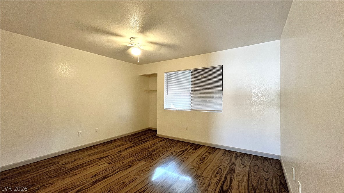 6750 Del Rey Avenue, Unit 123 Las Vegas, NV 89146 - Photo 11 of 21 Rich hardwood-style flooring extends across this generously sized bedroom, offering a versatile space for personalization.