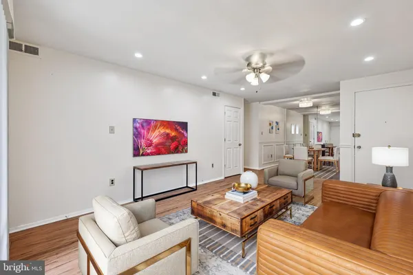 a living room with furniture a rug and a painting