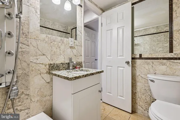 a bathroom with a granite countertop sink toilet and shower