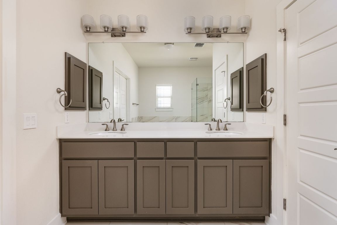 2401 McBee Street Austin, TX 78723 - Photo 23 of 36 Bathroom featuring double vanity and a marble finish shower