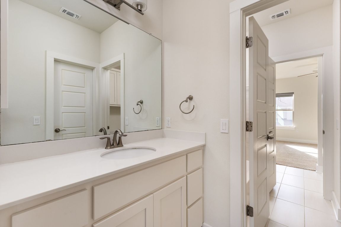 2401 McBee Street Austin, TX 78723 - Photo 28 of 36 Bathroom with vanity, light tile patterned floors, and light colored carpet