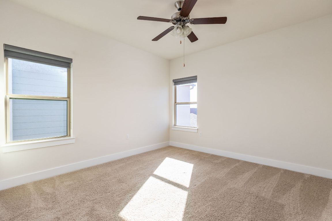 2401 McBee Street Austin, TX 78723 - Photo 30 of 36 Spare room with light colored carpet and a ceiling fan
