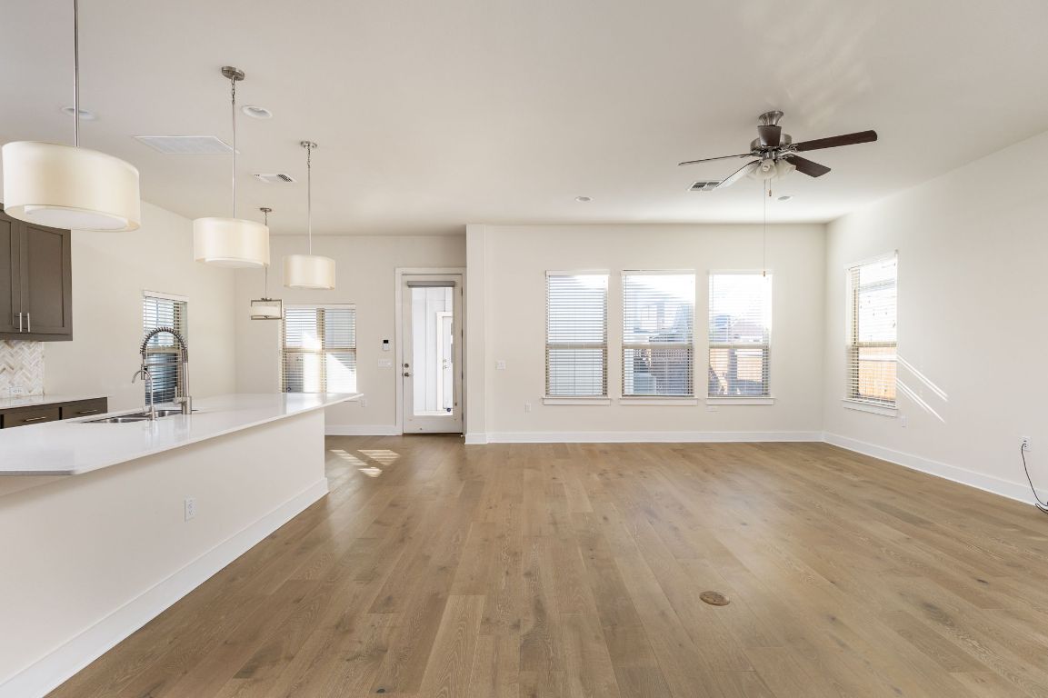 2401 McBee Street Austin, TX 78723 - Photo 5 of 36 Unfurnished living room with light wood finished floors, plenty of natural light, and a ceiling fan