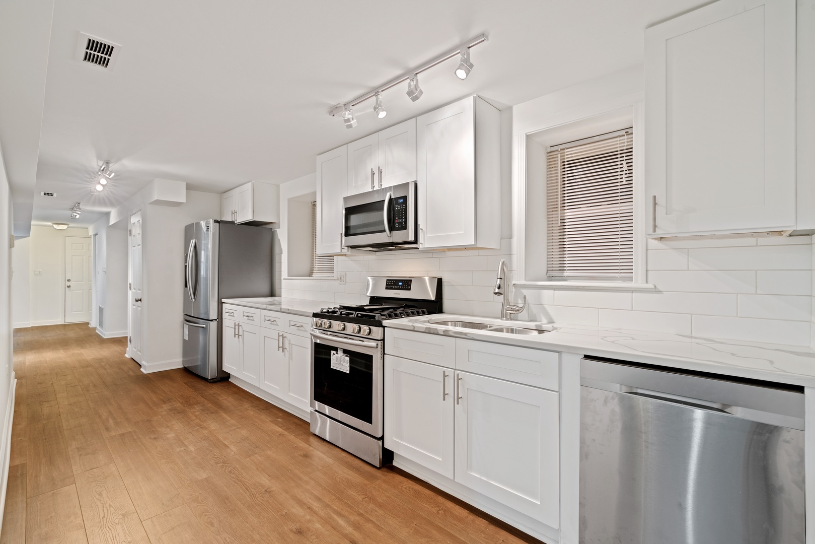 1734 West Erie Street, Unit G Chicago, IL 60622 - Photo 11 of 18 a kitchen with stainless steel appliances a refrigerator stove microwave and sink