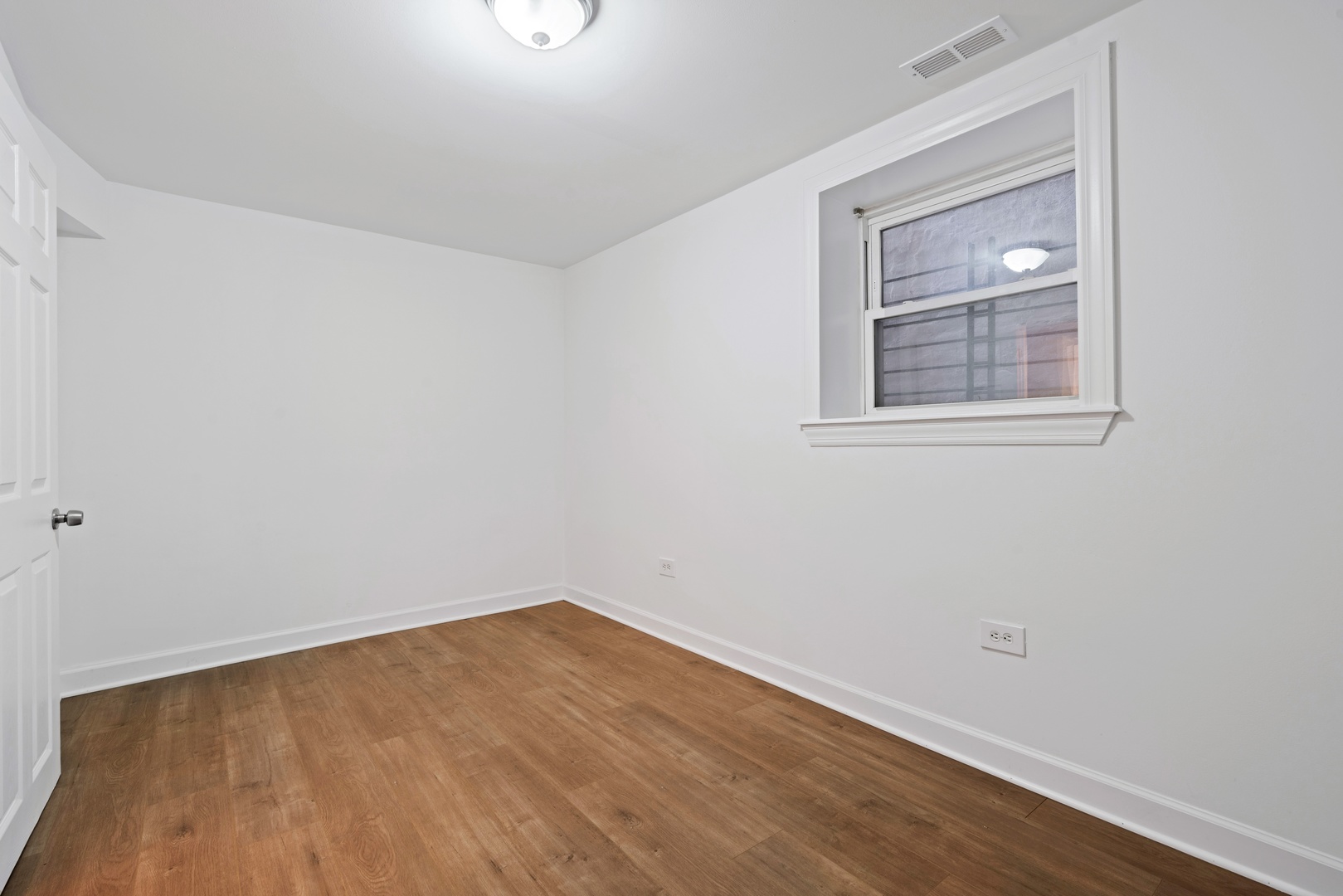 1734 West Erie Street, Unit G Chicago, IL 60622 - Photo 13 of 18 a view of an empty room with wooden floor and a window