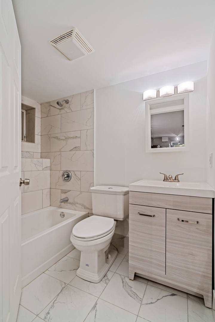 1734 West Erie Street, Unit G Chicago, IL 60622 - Photo 16 of 18 a bathroom with a sink toilet and shower